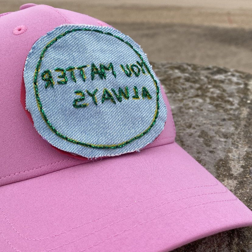 Pink cap with a patch on a beach