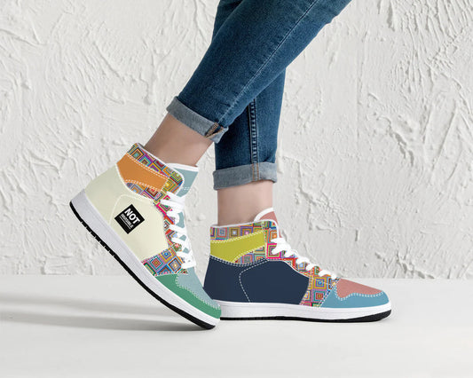Colorful patterned sneakers worn with blue jeans against a white background