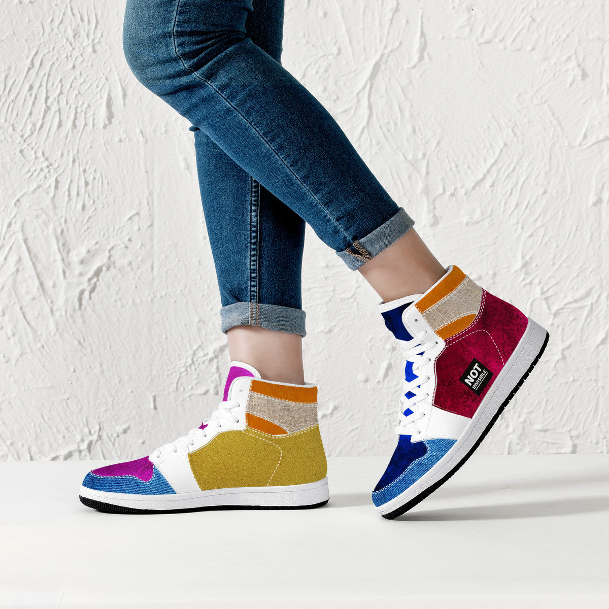 Colorful sneakers with a brand logo worn by a person against a light background