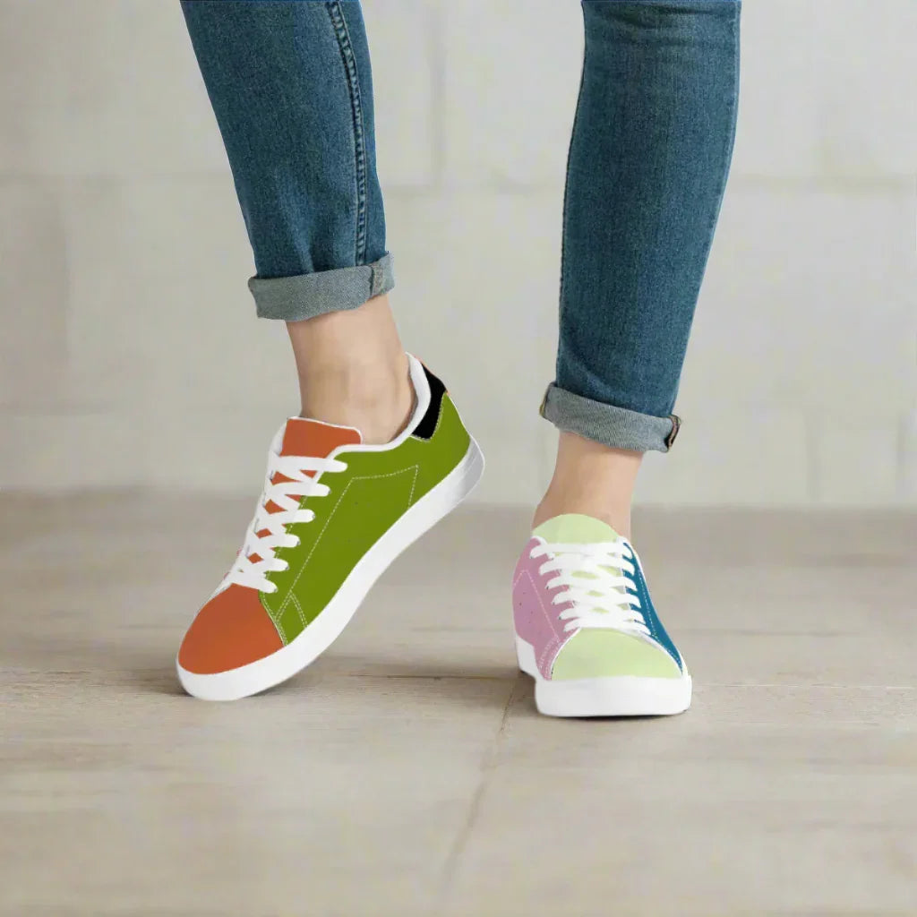 Colorful sneakers worn with rolled-up jeans on a neutral background
