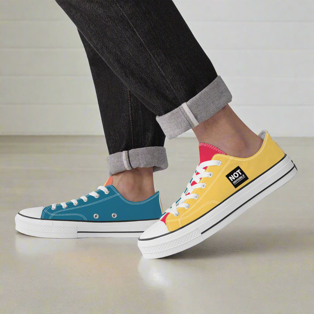 Two colorful sneakers, one blue and one yellow with white soles, worn by a person.