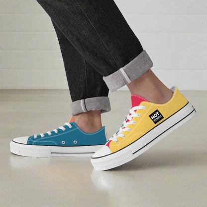 Two colorful sneakers, one blue and one yellow with white soles, worn by a person.