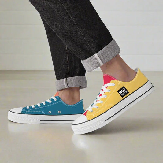 Two colorful sneakers, one blue and one yellow with white soles, worn by a person.